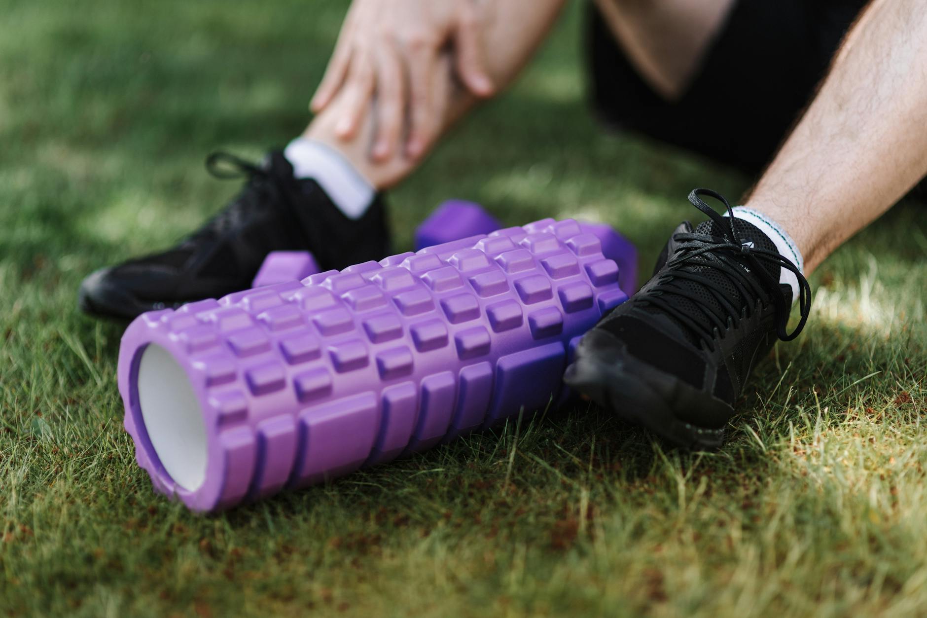 Runner using foam roller on leg muscles for post-run recovery