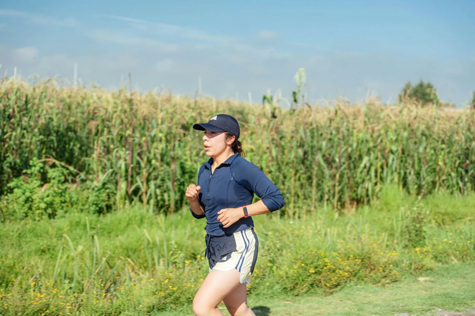 Runner wearing a lightweight cap shielding sun during a summer outdoor run