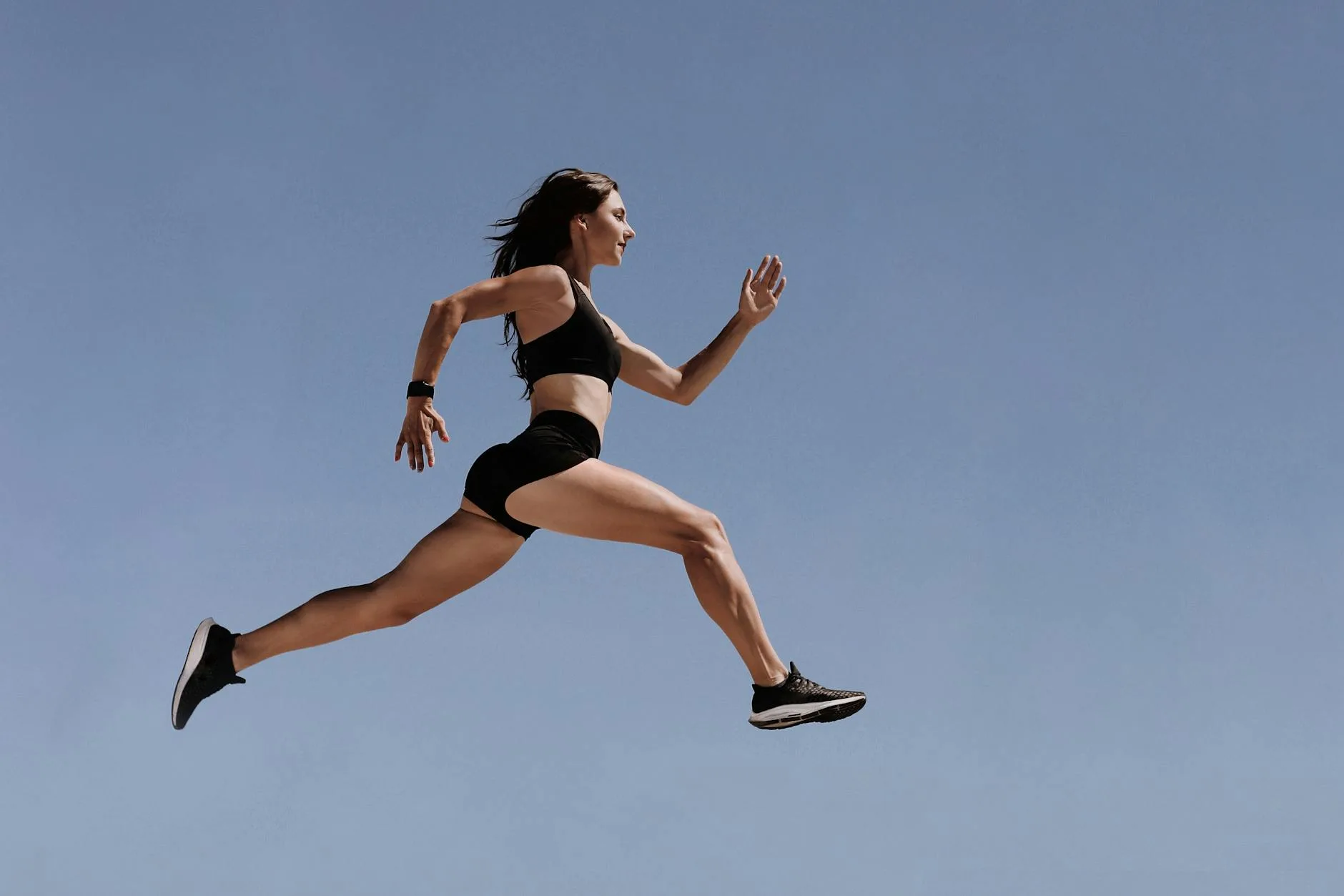 Runner sitting on ground catching breath, head down, shoes tied, ready to rise again