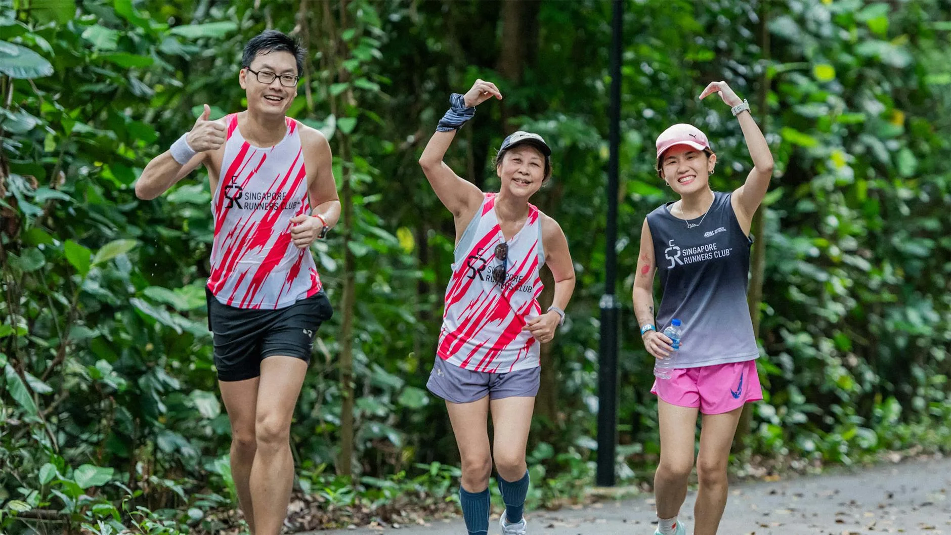 Diverse group of runners jogging together through a sunny park trail