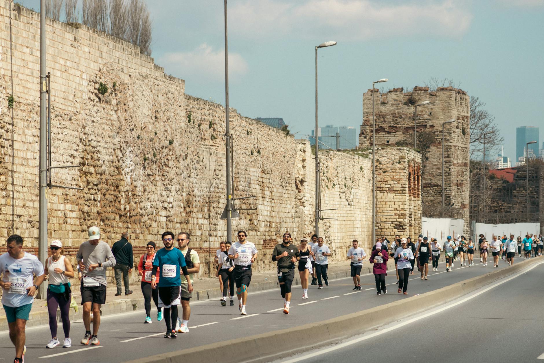 Runner struggling near mile 20 of a marathon, visibly fatigued and slowing down