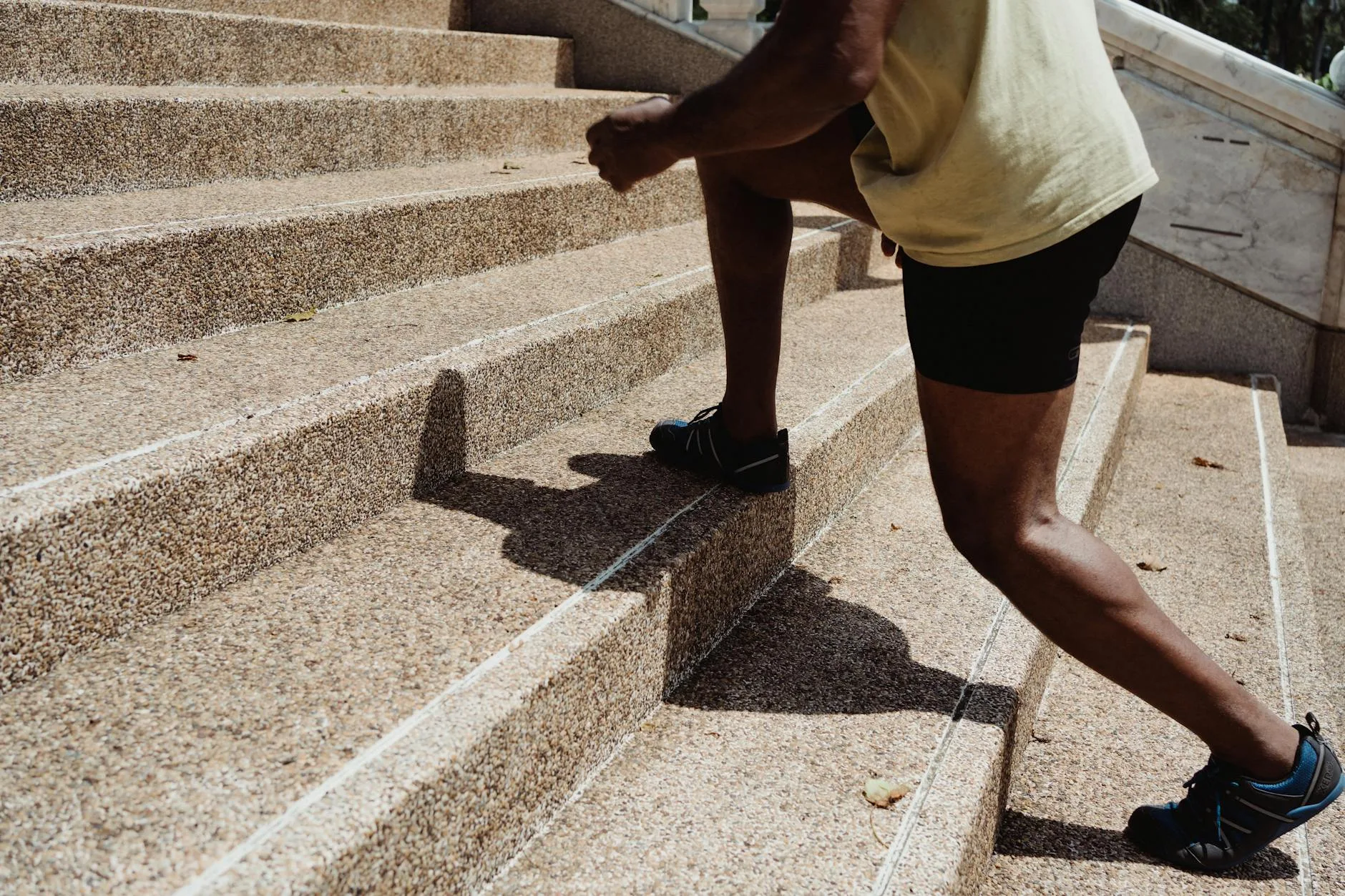 Runner maintaining upright posture with aligned spine and relaxed shoulders mid-stride outdoors.
