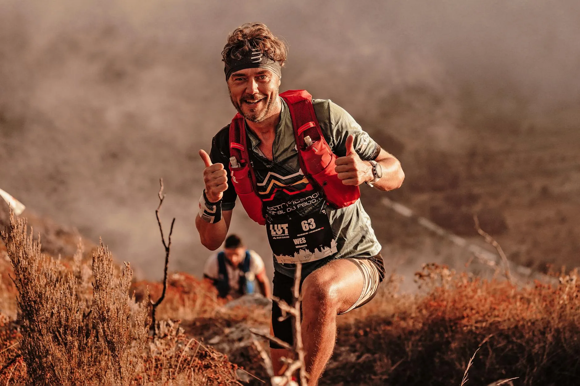 Runner navigating rocky mountain trail through dense forest during first trail race