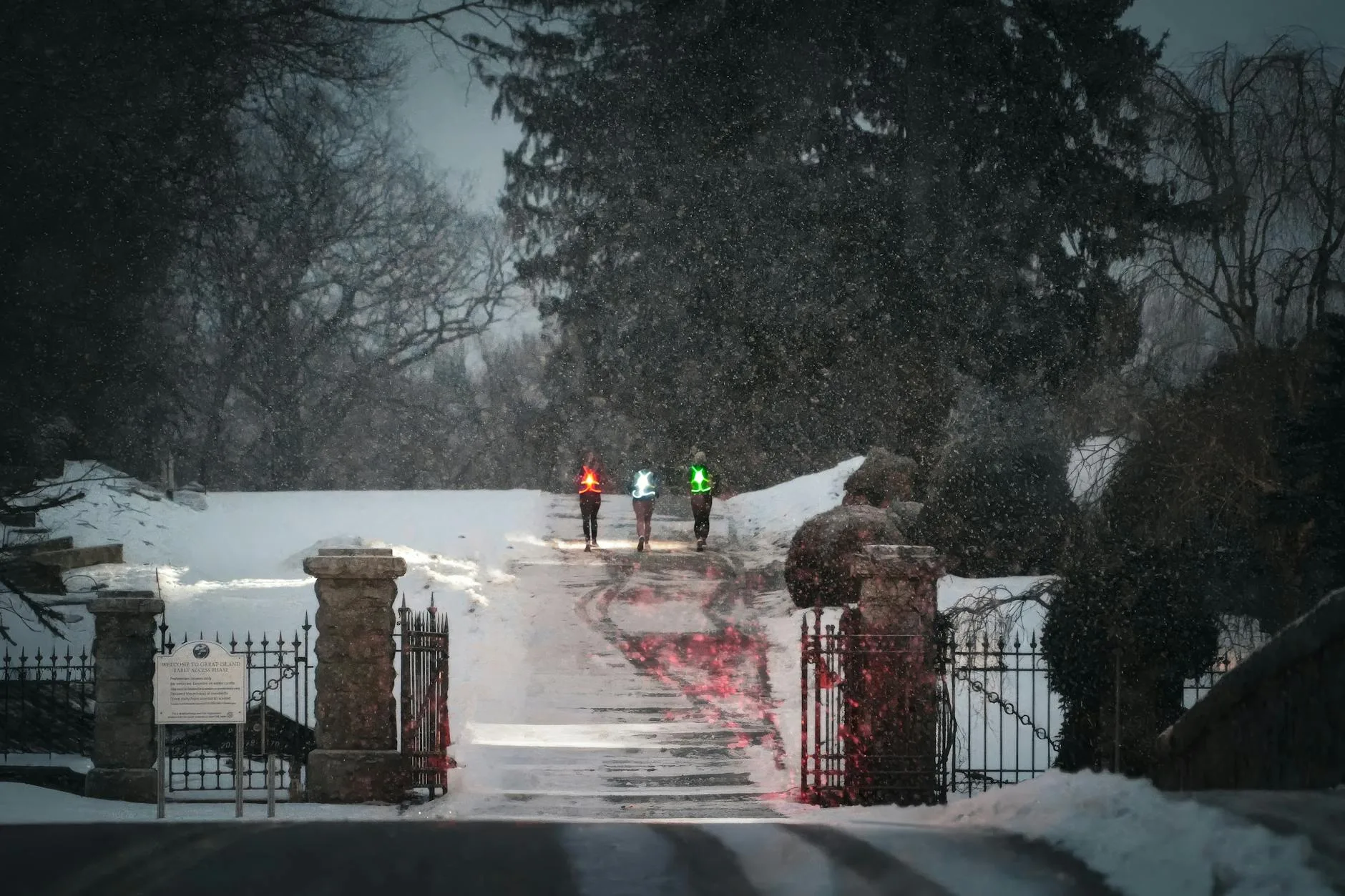 Runner wearing reflective gear and headlamp on a dark winter road at night
