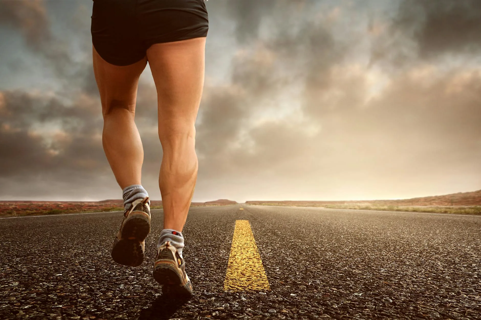 Runner gripping painful glute muscle during outdoor training session