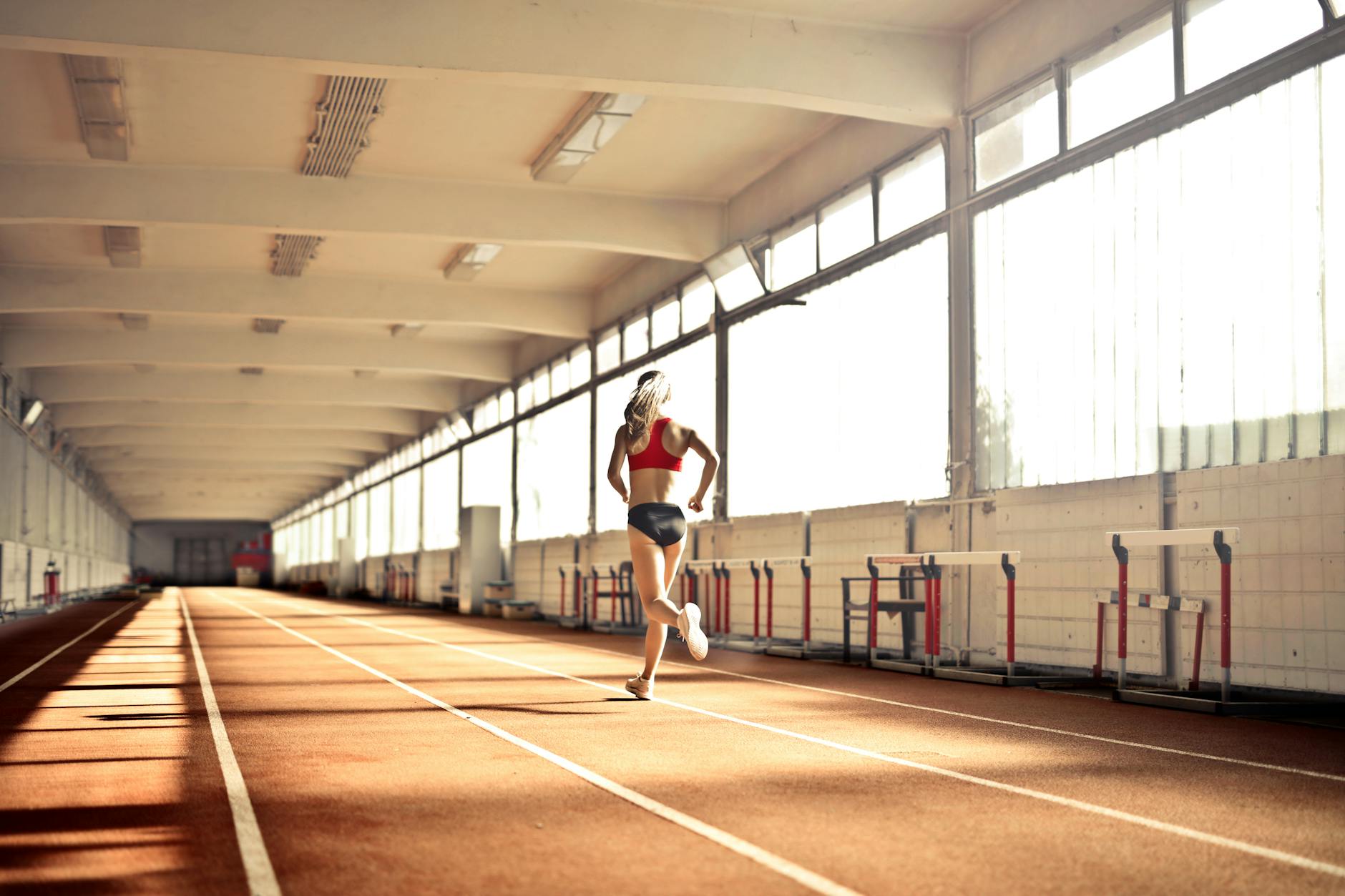 Runner stretching foot to relieve plantar fasciitis pain on track