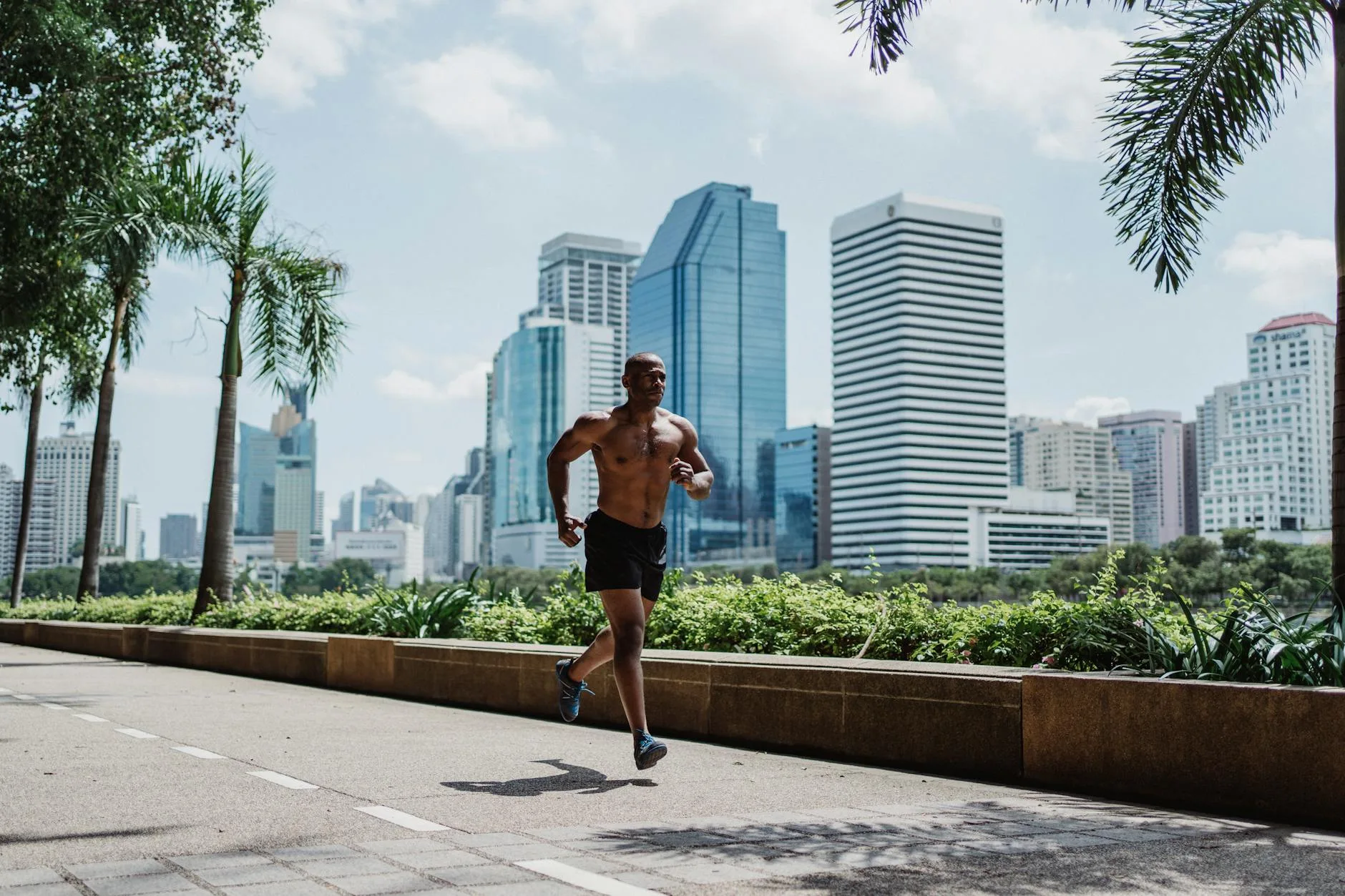 Runner sprinting through park, face tense, releasing stress on a tree-lined path