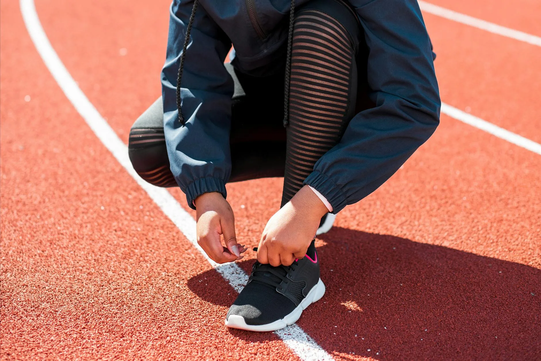 Runner executing a powerful stride on an open road, legs extended mid-sprint