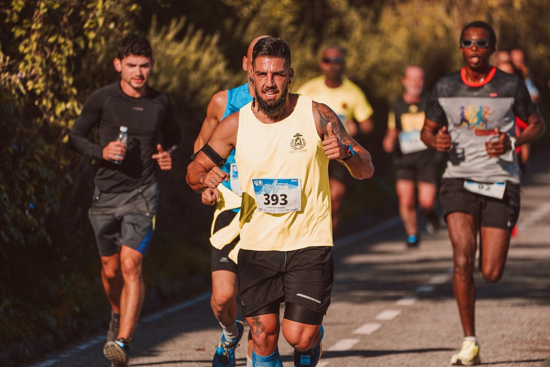 Runner maintaining steady pace on open road, focused expression, mid-stride