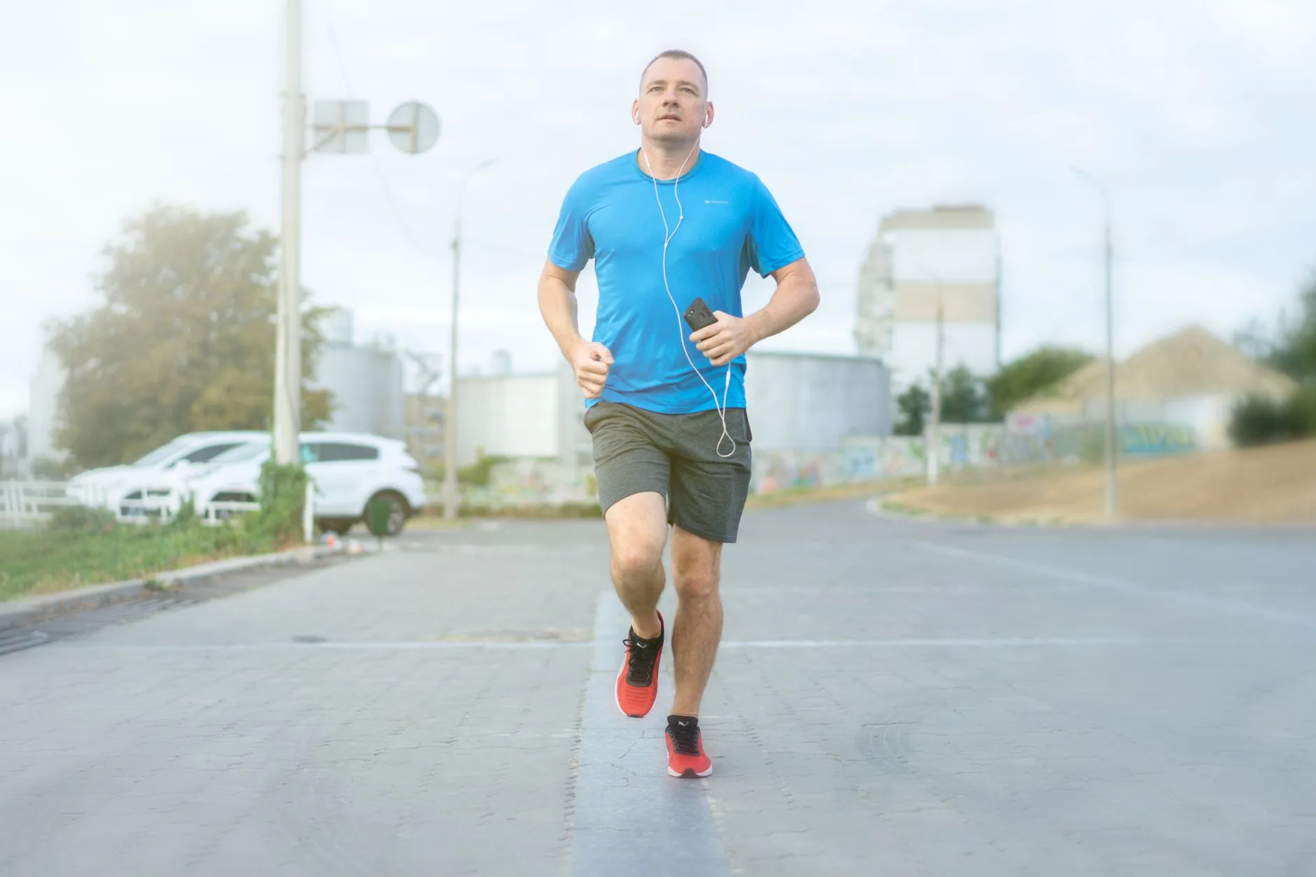 Runner tracking mileage on smartwatch during outdoor training session on scenic trail