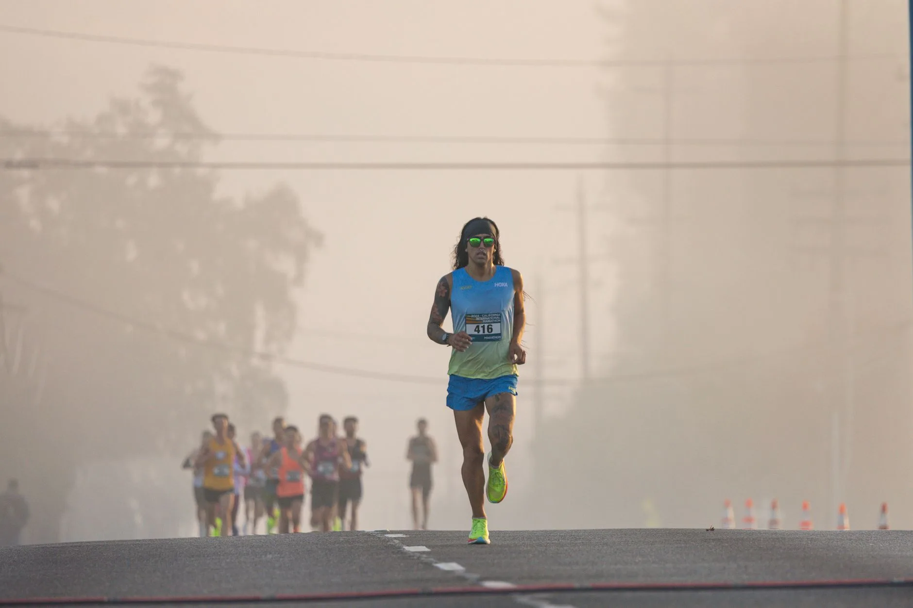 First-time runner crossing marathon finish line with arms raised in triumph