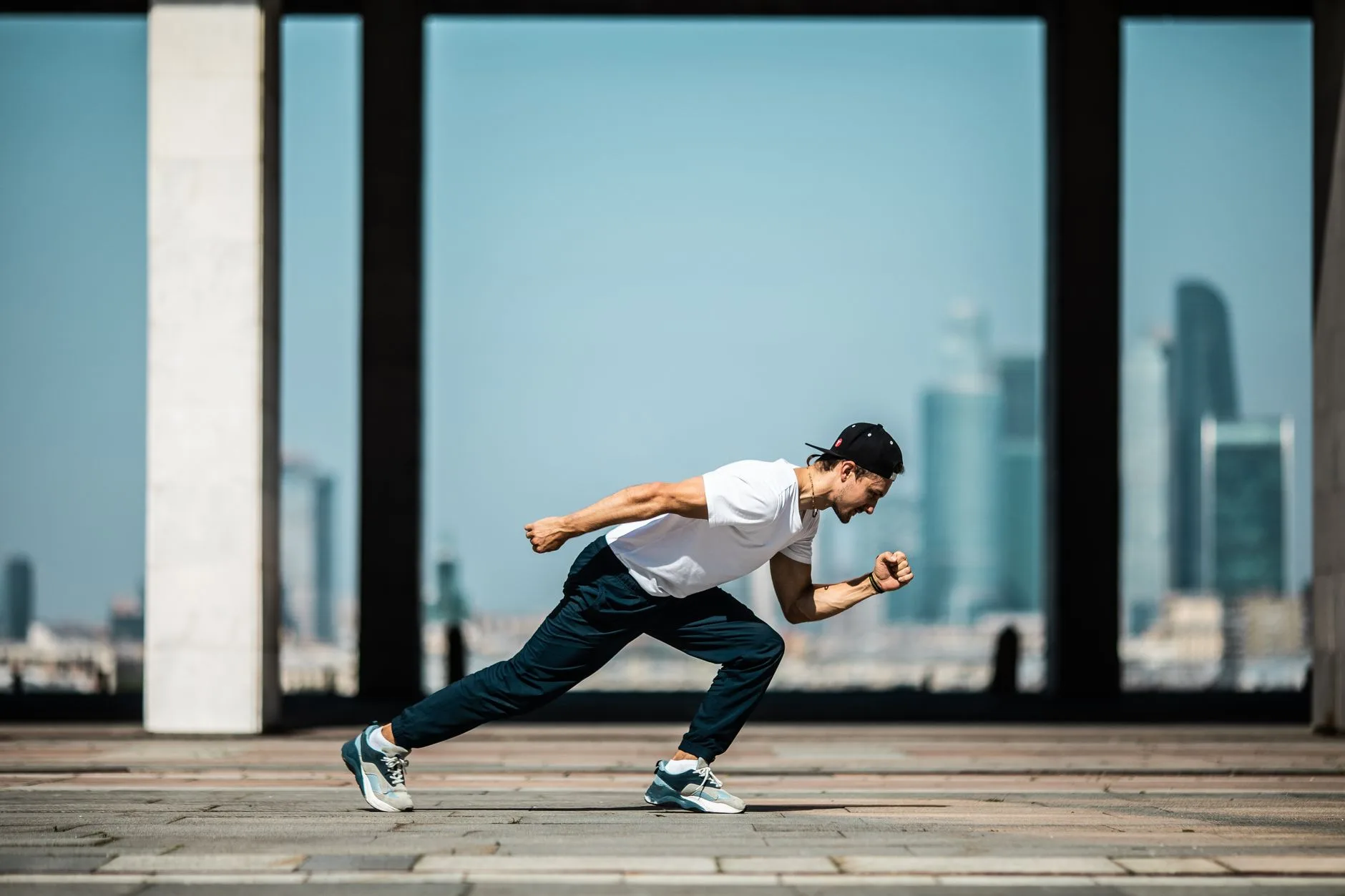 Runner checking watch while striding on a trail, focused on cadence and pace