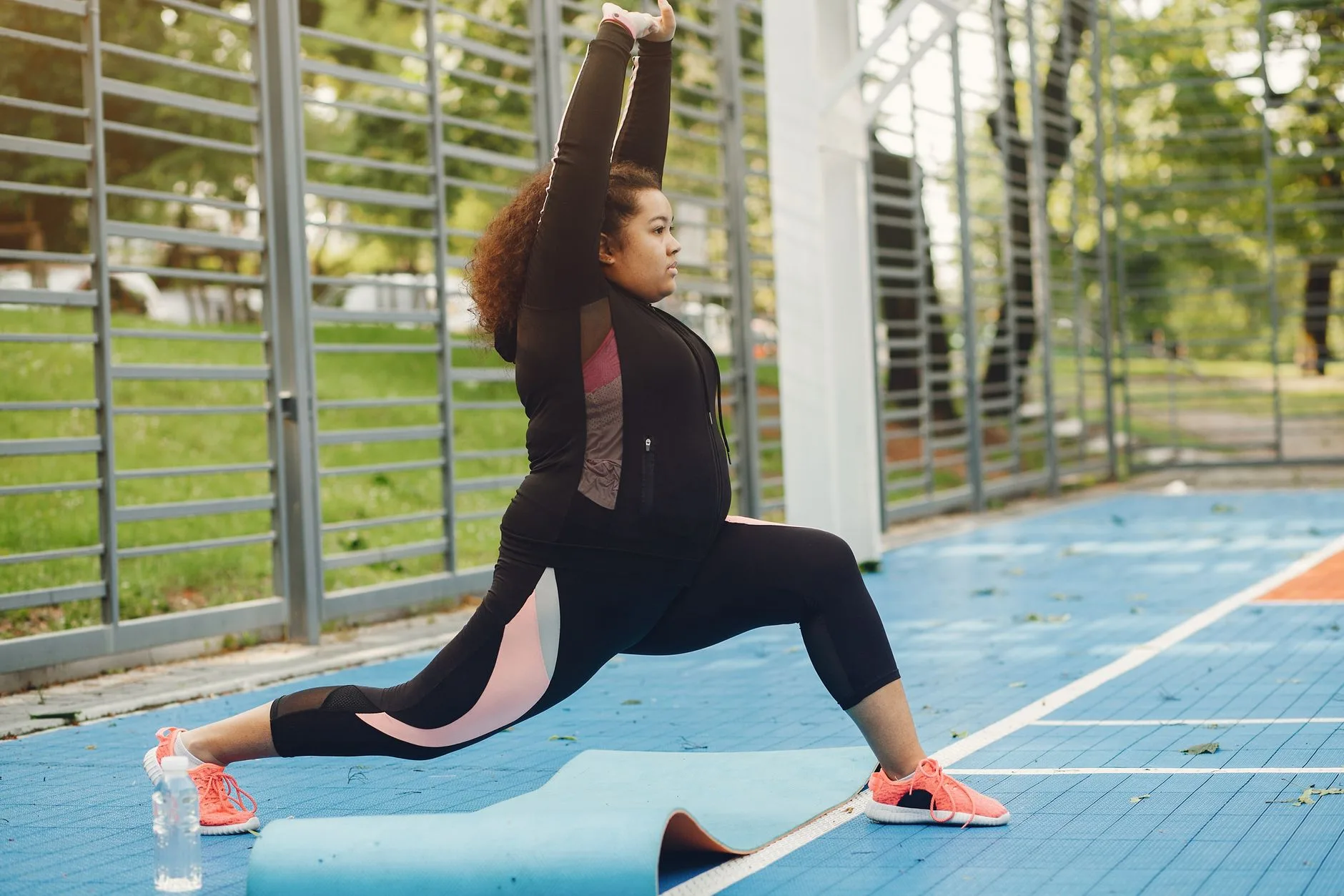 Overweight beginner jogging on a park path in supportive running shoes