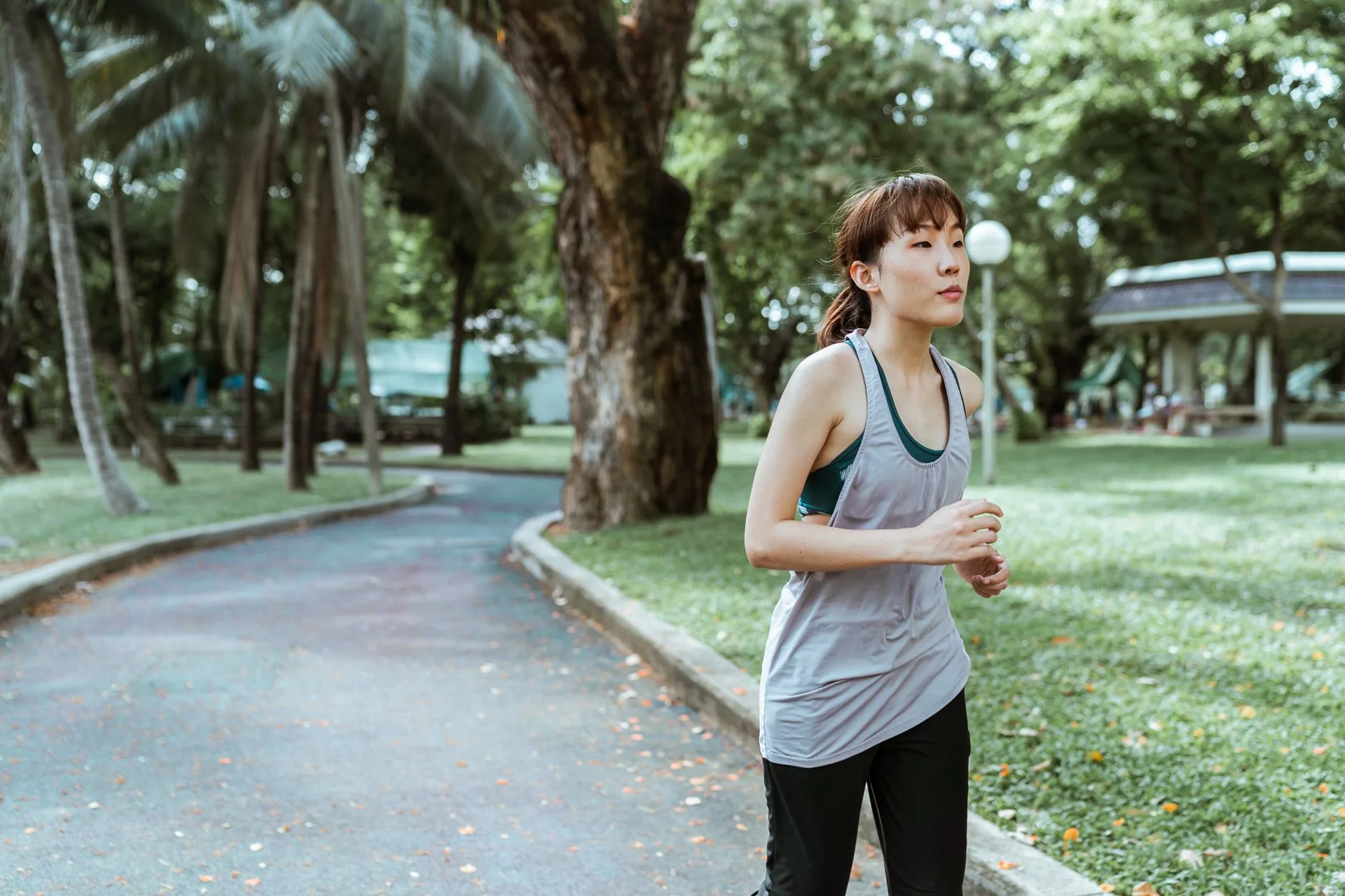 Runner using inhaler outdoors before a morning jog on a sunny trail
