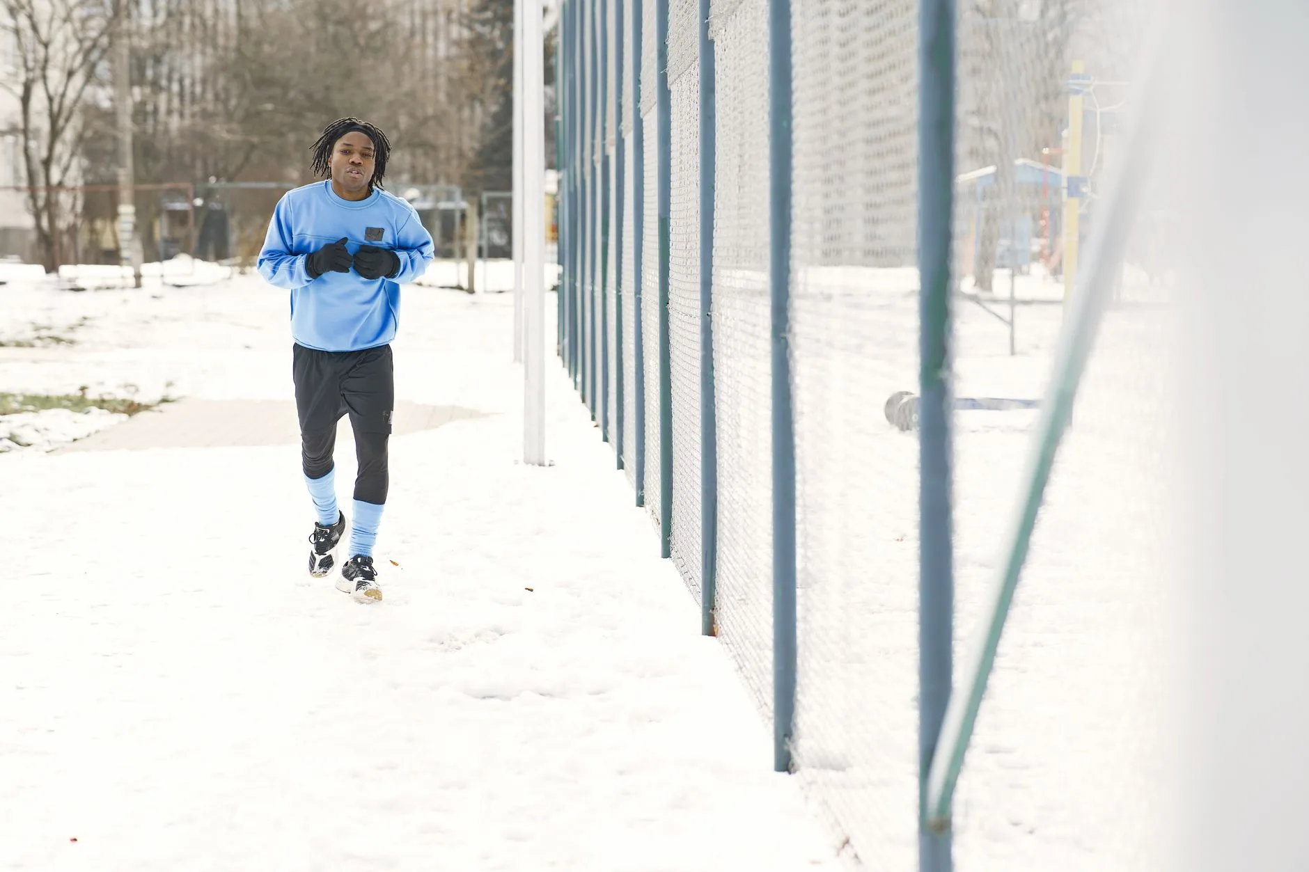 Runner in thermal layers and gloves jogging on a frosty UK winter morning