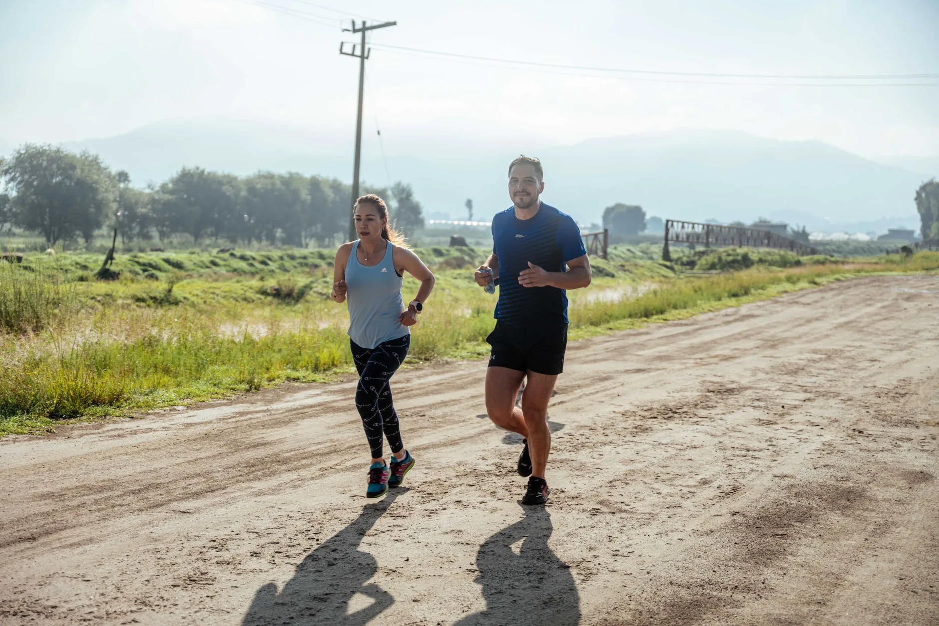 Running coach reviewing training data with athlete on track during outdoor session