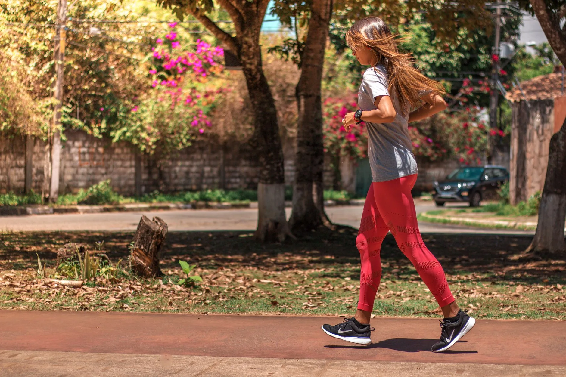 Runner writing in a training journal beside running shoes and a stopwatch