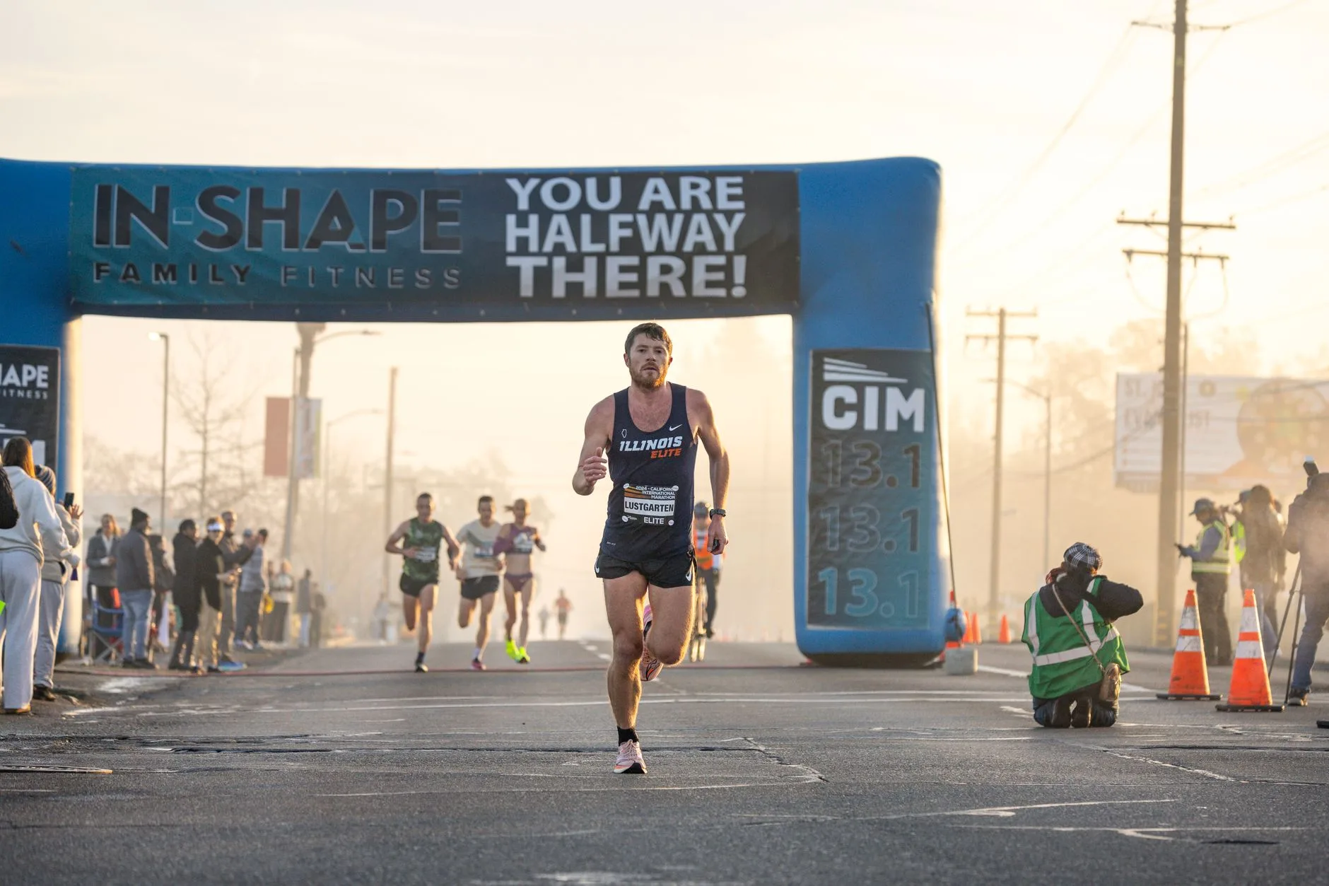Runner grimacing with determination while pushing through a tough uphill stretch