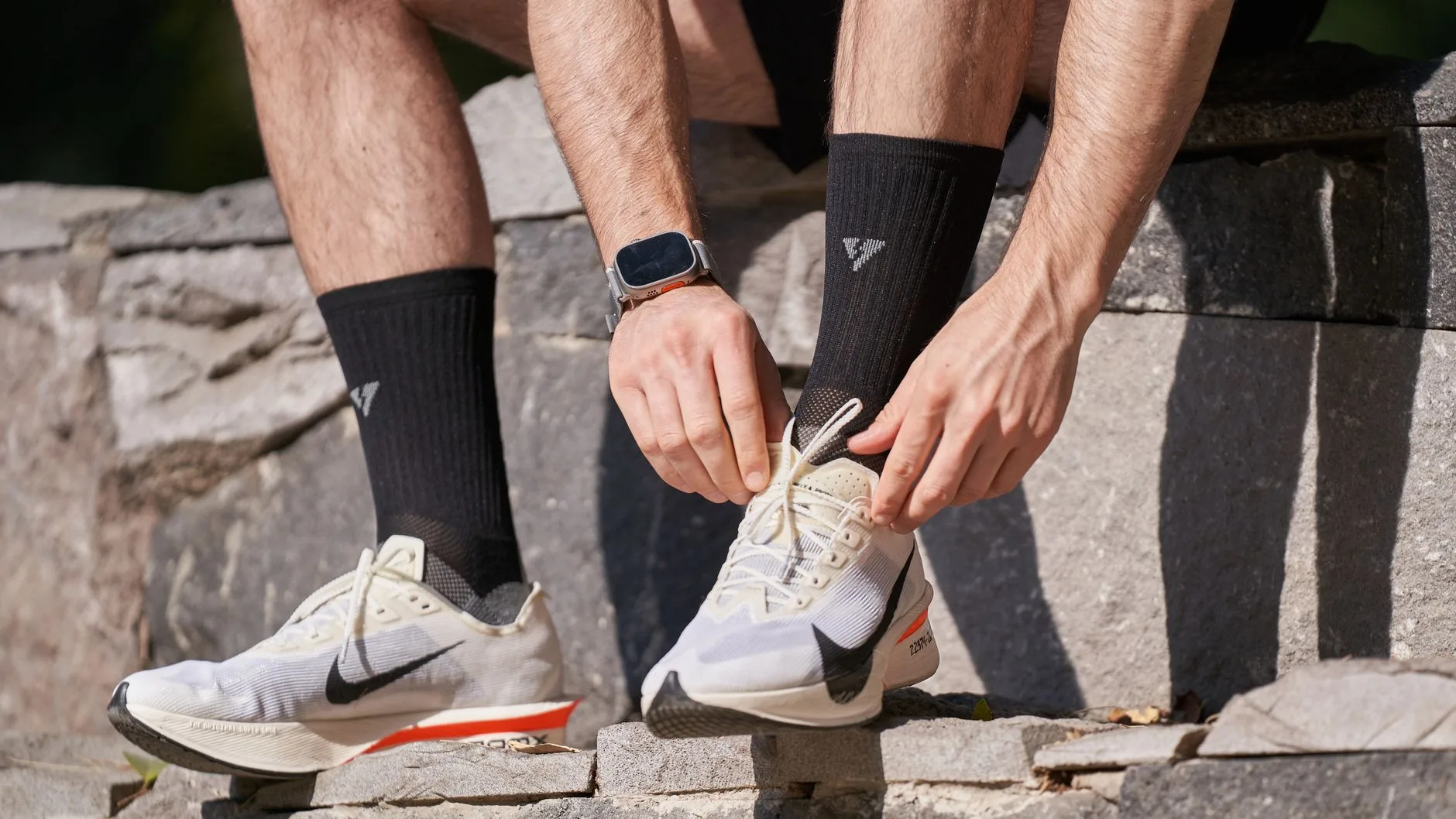 Runner's feet in minimalist shoes striking a forest trail mid-stride