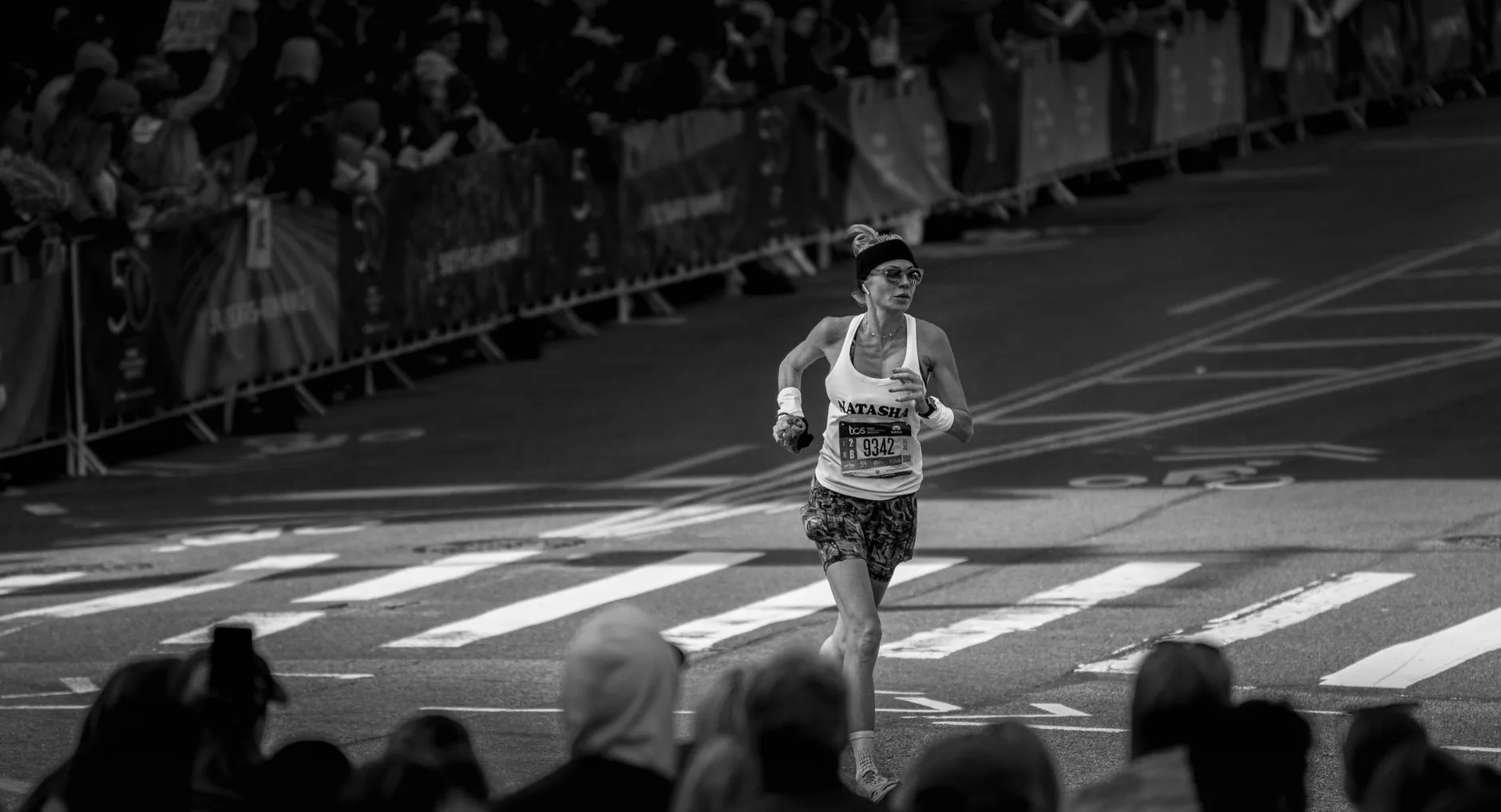 Runners crossing the New York City Marathon start line with skyline in background