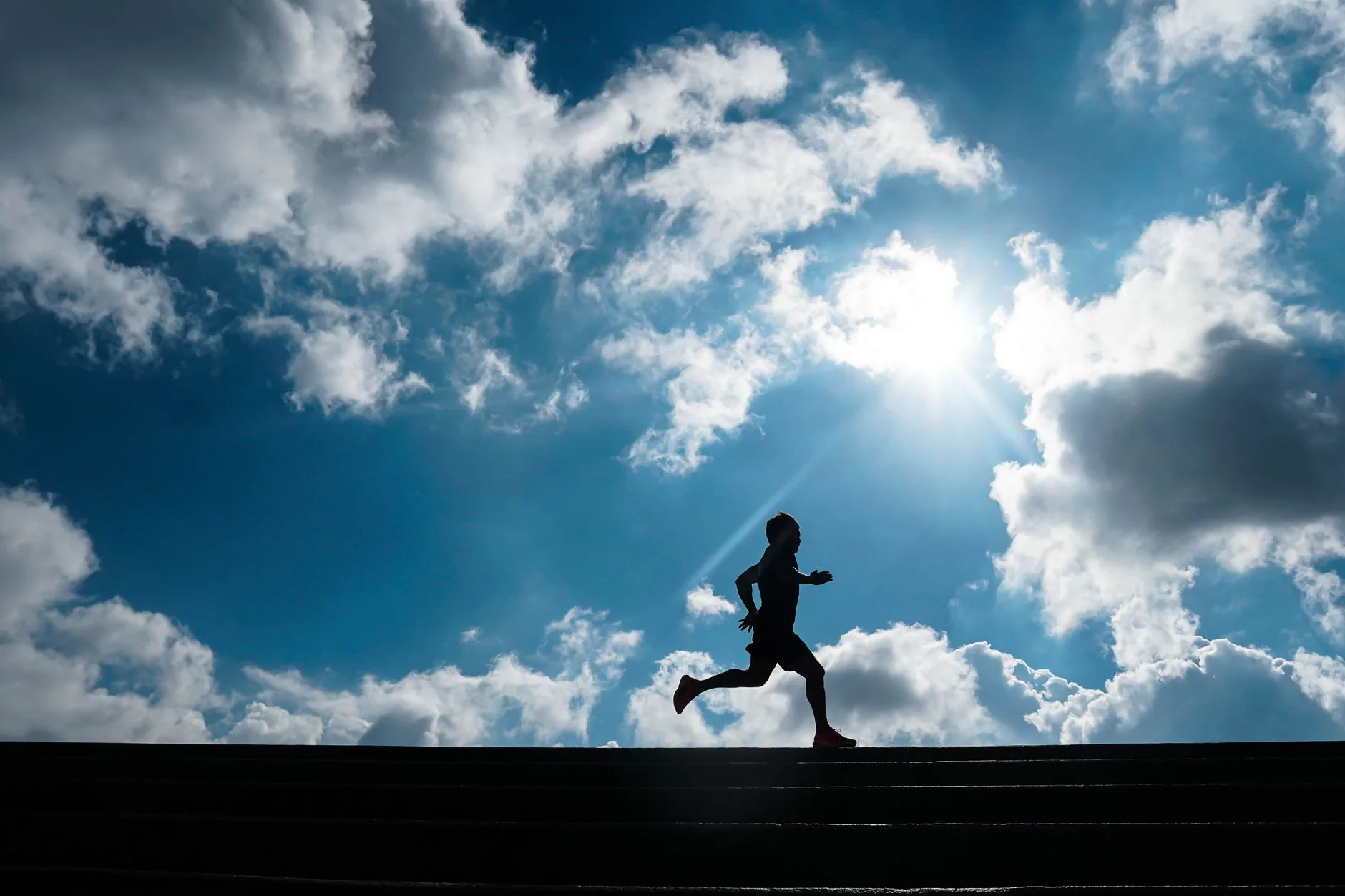 Runner jogging alone on a quiet trail at sunrise, embodying calm mental focus