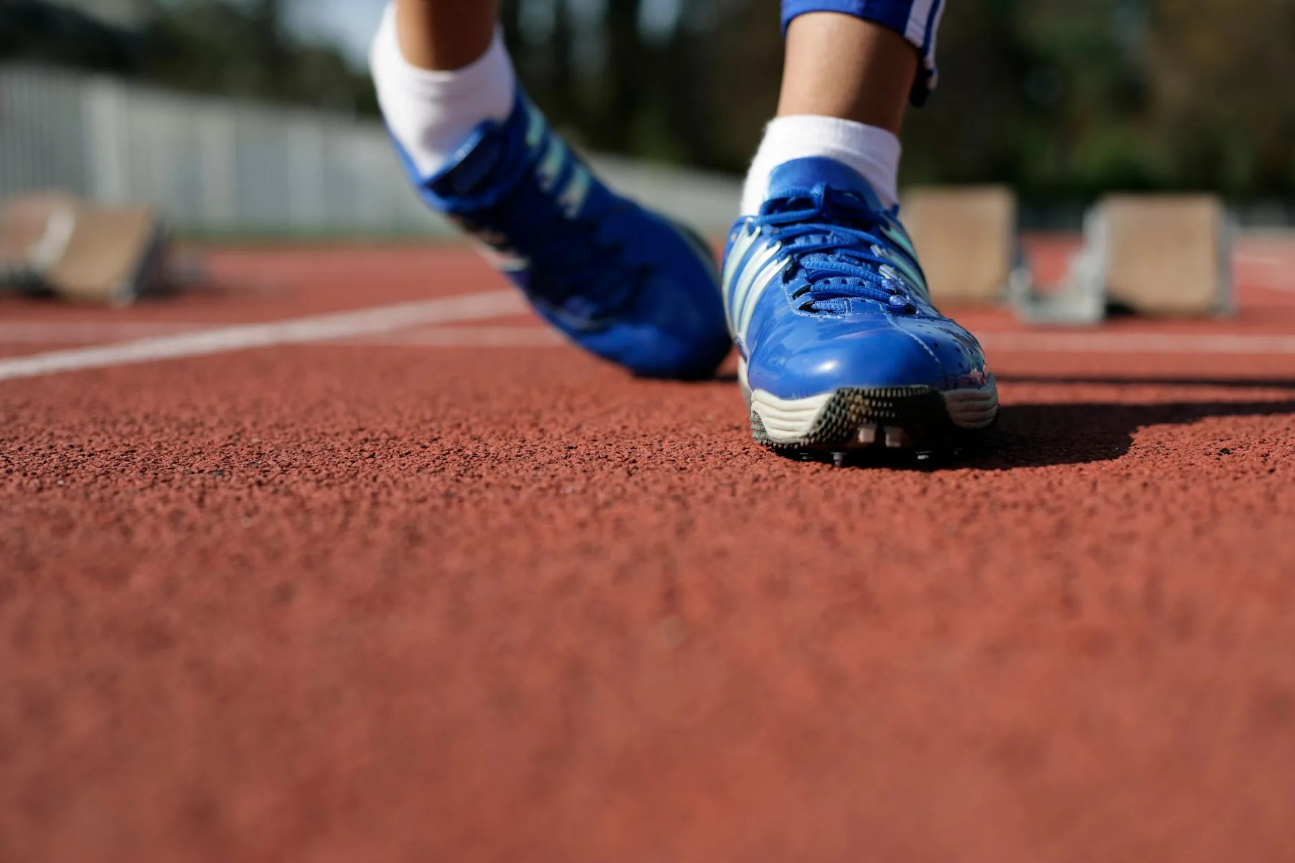 Bare feet striking a dirt trail mid-stride, showcasing natural running form