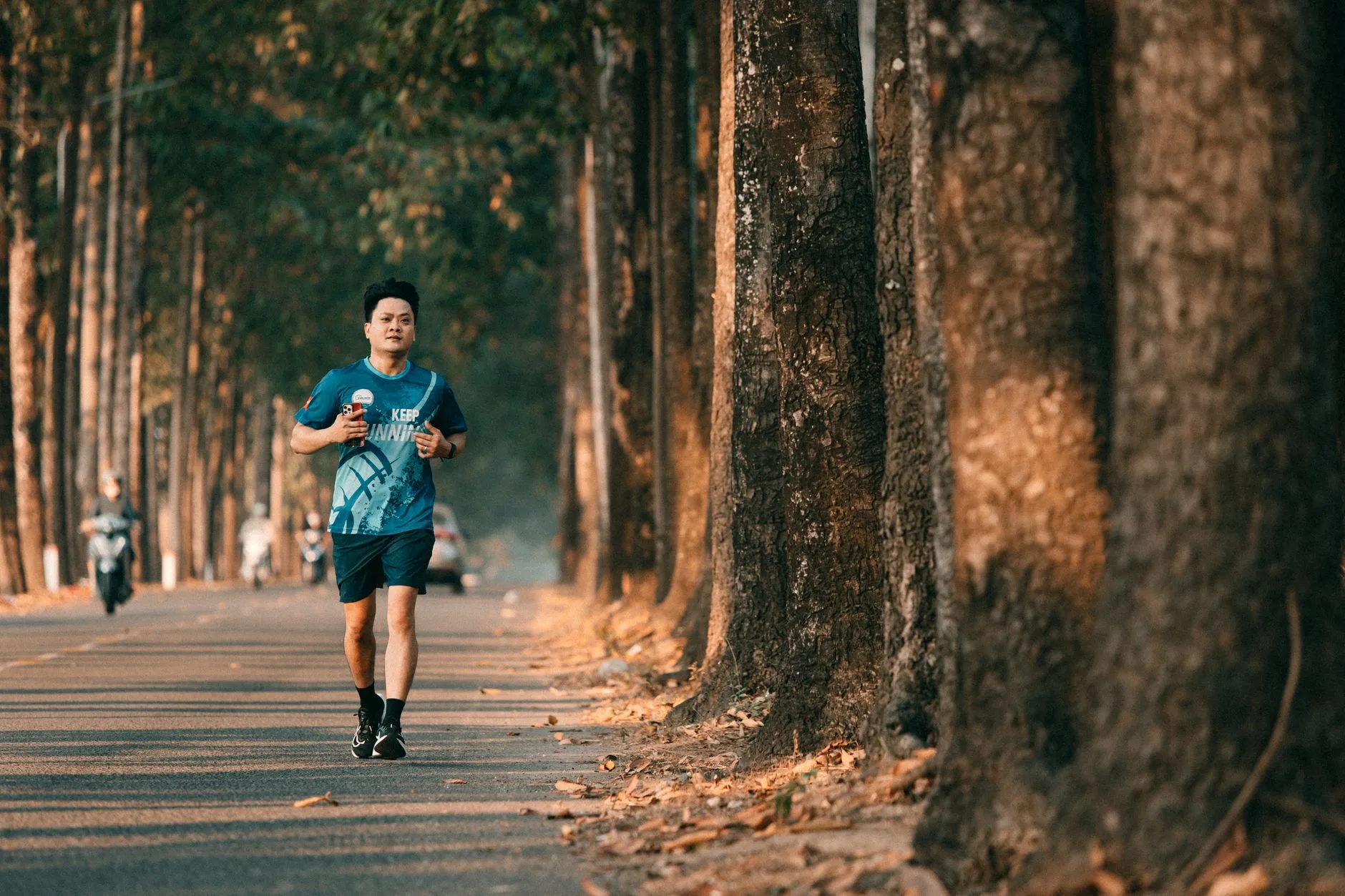 Runner eating a banana and holding a glass of chocolate milk after a workout