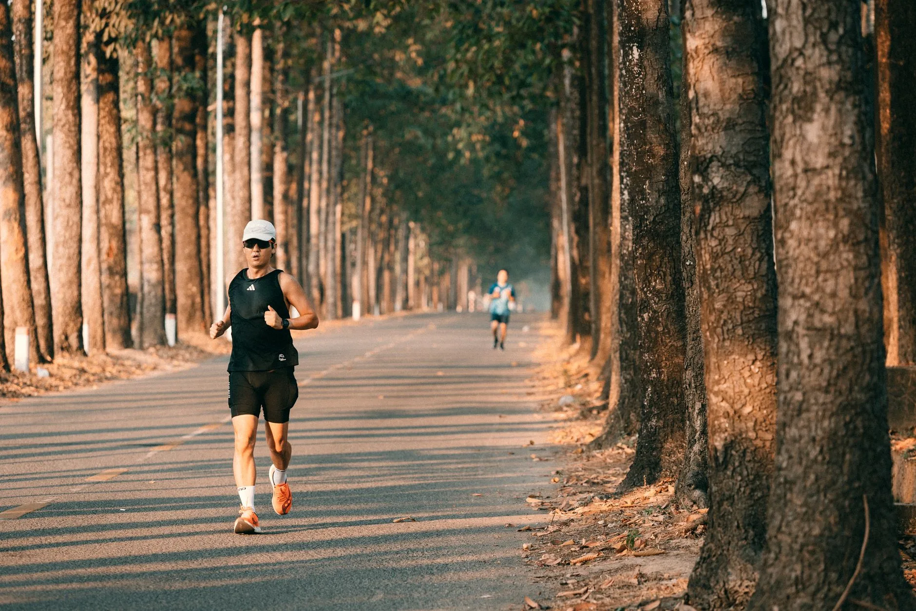 Runner in reflective gear using a headlamp on a dark trail at night
