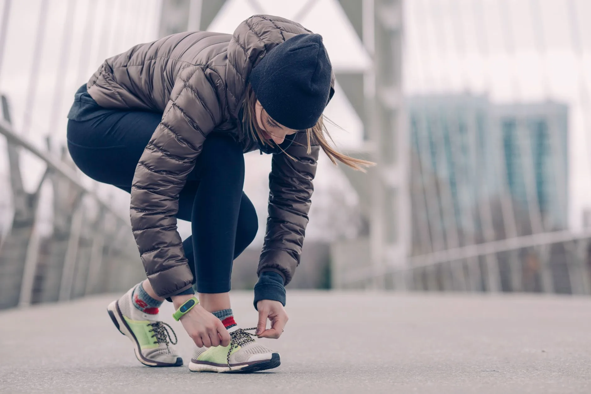 Runner bundled in layered gear jogging along a frosty trail in winter